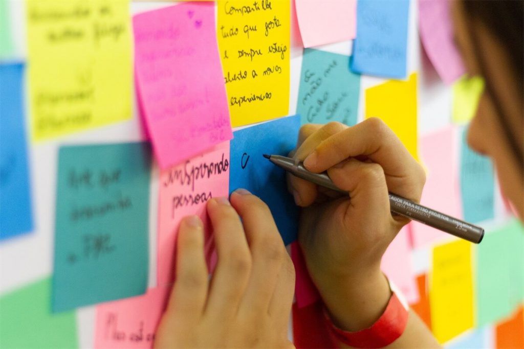 Woman writing down key points on her sticky notes for her Debt Consolidation Plan in Singapore