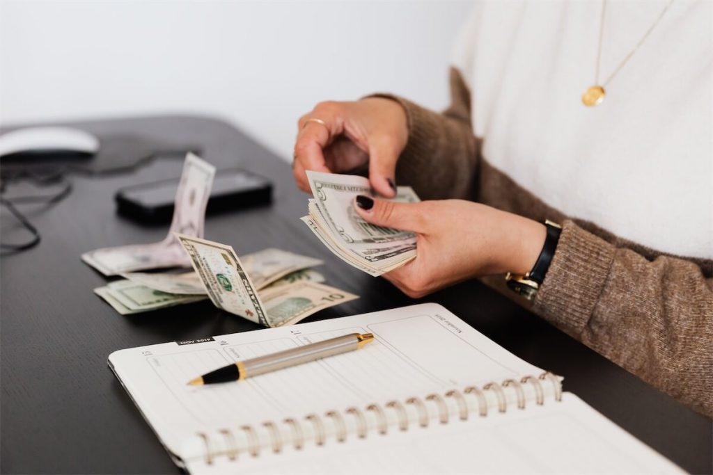 A woman counting the emergency cash fund that she saved from opting to a longer tenure for her home loan in Singapore