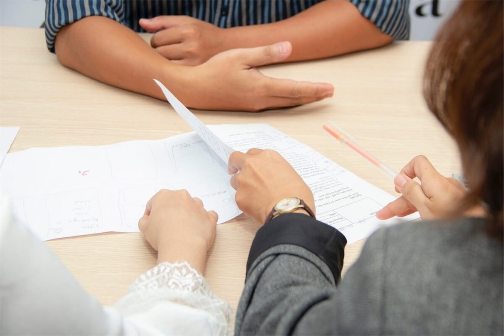 A couple looking through some paperwork for their home loan application with a mortgage broker in Singapore